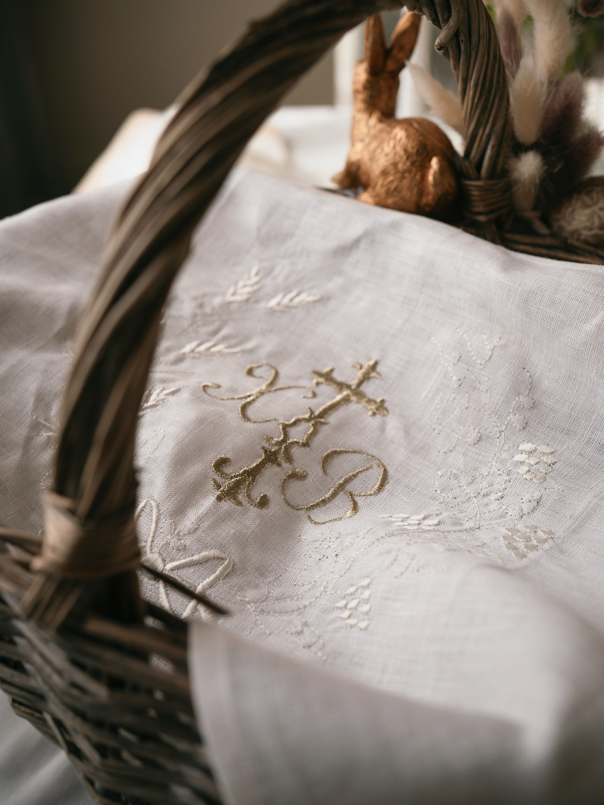 Embroidered fabric with decorative patterns and a wicker basket.