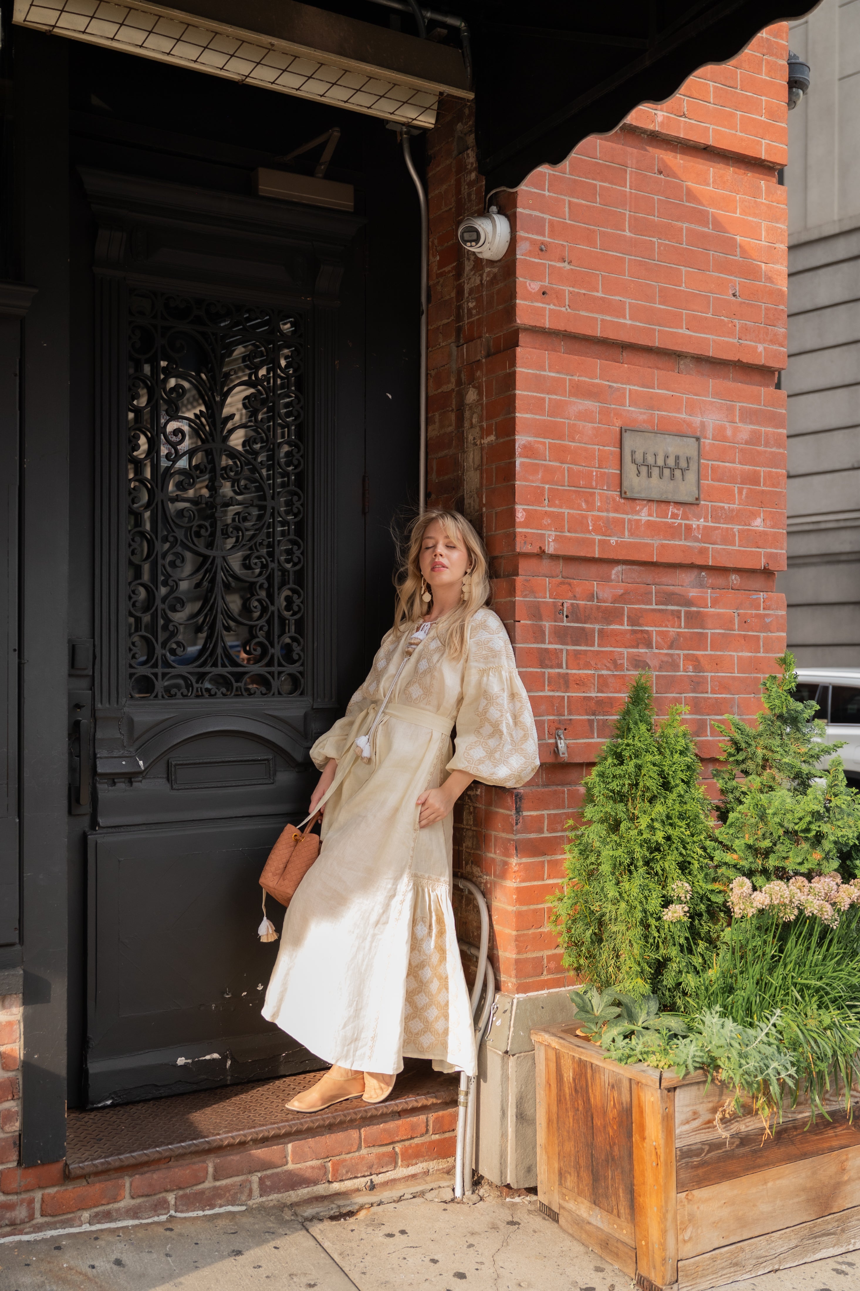 ANNABO Svitanok maxi dress in cream beige linen with geometric embroidery, voluminous sleeves, tasseled neckline ties, and flowing maxi silhouette. Crafted from 100% linen in a timeless artisanal-inspired design.
